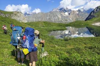 Backpackers check out the perfect reflection in an alpine lake Anya Voskresensky